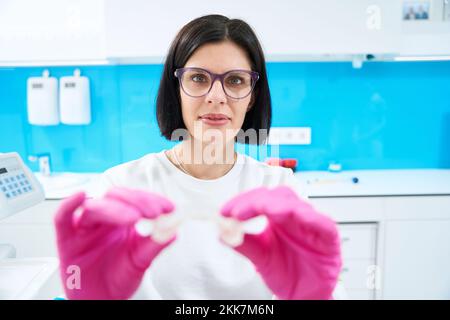 L'ortodontista tiene in mano un cappuccio trasparente Foto Stock