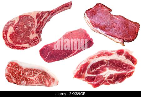 Set di vari picchetti di manzo crudo isolati su fondo bianco. Vista dall'alto della collezione di carni crude tagliate Foto Stock