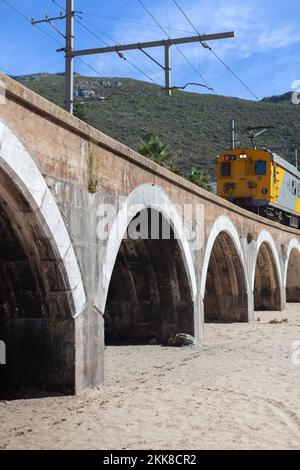 Treno sul ponte con montagna sullo sfondo a Kalk Bay Città del Capo Sud Africa Foto Stock