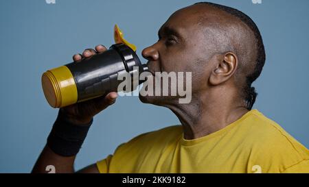 Primo piano uomo atletico stanco atleta prendere pausa durante l'allenamento bere acqua fresca da sport bottiglia dissetare dopo l'esercizio adulto Foto Stock