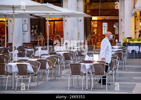 Venezia, Italia - 5 luglio 2021: Il cameriere attende i clienti al famoso caffè Floria in Piazza San Marco a Venezia. Indossa una maschera per proteggere l'agsinst Foto Stock