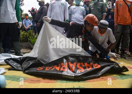 Cianjur, Giava Occidentale, Indonesia. 25th Nov 2022. Le persone preparano un processo di sepoltura sul corpo di 7 anni Asika Nur Fauziah, che è sepolto in rovine a seguito del terremoto di magnitudo 5,6 che è accaduto nel distretto di Cugenang, Cianjur, Giava Occidentale, Indonesia. (Credit Image: © Dicky Bisinglasi/ZUMA Press Wire) Foto Stock