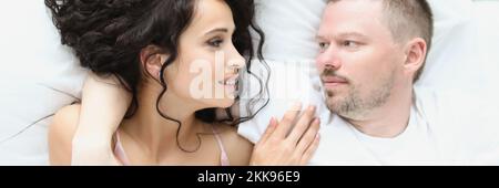 Una coppia deliziosa che si abbraccia a letto la mattina, una famiglia ben riposata che si gode stare a letto Foto Stock