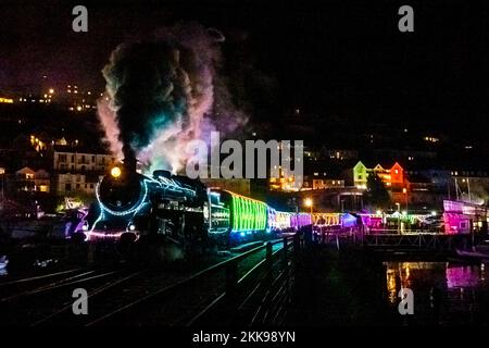 Kingswear, Devon, Regno Unito. 25th novembre 2022. Il treno di luci di Natale sulla ferrovia a vapore di Dartmouth che corre tra il 25th novembre e il 30th dicembre 2022 tira fuori dalla stazione Kingswear a Devon sulla sua strada per Paignton. Le carrozze e le locomotive a vapore del servizio festivo sono illuminate all'interno e all'esterno con luci colorate. Picture Credit: Graham Hunt/Alamy Live News Foto Stock