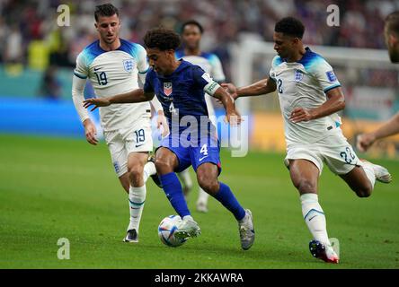 Tyler Adams (al centro) degli Stati Uniti batte con Jude Bellingham (a destra) e Mason Mount in Inghilterra durante la partita di Coppa del mondo FIFA Group B allo stadio al Bayt di al Khor, Qatar. Data immagine: Venerdì 25 novembre 2022. Foto Stock