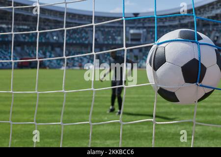 il giocatore di calcio calcia la palla nel gol dello stadio Foto Stock