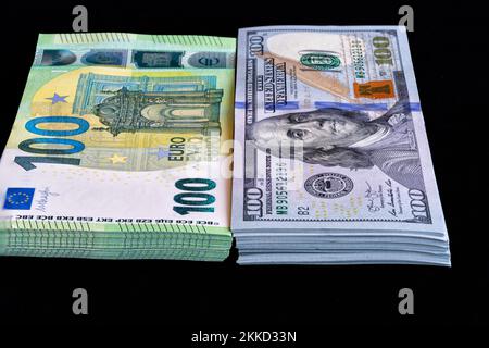 Pile di banconote in dollari USA ed euro su sfondo nero. Concetto finanziario Foto Stock