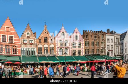 Bruges, Belgio - 20 ottobre 2018: I turisti godono di una splendida giornata di sole e scattano foto nella Piazza del mercato (Markt) di Bruges. Foto Stock