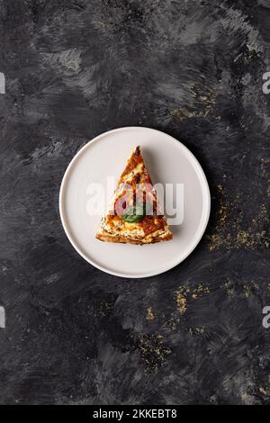 Una vista verticale dall'alto di un'appetitosa fetta di pizza, la pizza margherita con sopra un basilico Foto Stock
