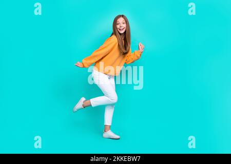 Foto a corpo pieno di giovane donna eccitata carina indossare abiti alla moda ballare festeggiamento fine settimana relax isolato su sfondo color acquamarina Foto Stock