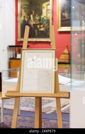 Leinfelden Echterdingen, Germania. 25th Nov 2022. La casa d'aste Eppli di Stoccarda, oltre ad altri oggetti sul tema della 'royalty Britannica', una lettera manoscritta di due pagine della regina Elisabetta II (1926-2022) recentemente deceduta dal 1966 ad una appassionata donna di cavalli. Su un cavalletto si trova l'oggetto da mettere all'asta. È la lettera incorniciata, una copia del retro e della busta. Credit: Julian Rettig/dpa/Alamy Live News Foto Stock