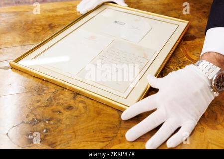 Leinfelden Echterdingen, Germania. 25th Nov 2022. La casa d'aste Eppli di Stoccarda, oltre ad altri oggetti sul tema della 'royalty Britannica', una lettera manoscritta di due pagine della regina Elisabetta II (1926-2022) recentemente deceduta dal 1966 ad un appassionato equestre. Ferdinand Eppli presenta l'oggetto da mettere all'asta. È la lettera incorniciata, una copia del retro e della busta. Credit: Julian Rettig/dpa/Alamy Live News Foto Stock