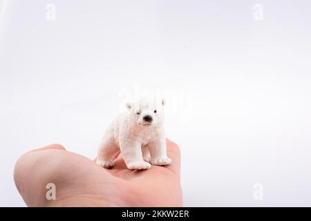 Mano che tiene un orso polare modello Foto Stock