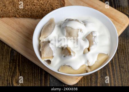 Gnocchi cotti di pasta con carne all'interno, gnocchi cotti e caldi con panna acida Foto Stock