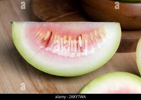 tagliare il cocomero non maturo su una tavola, tagliarlo a pezzi di piccole dimensioni Foto Stock