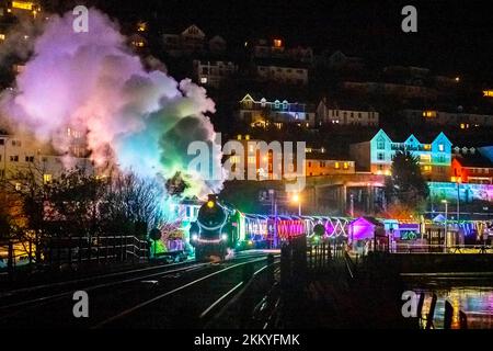 Kingswear, Devon, Regno Unito. 25th novembre 2022. Il treno di luci di Natale sulla ferrovia a vapore di Dartmouth che corre tra il 25th novembre e il 30th dicembre 2022, tira fuori dalla stazione Kingswear a Devon sulla strada per Paignton. Le carrozze e le locomotive a vapore del servizio festivo sono illuminate all'interno e all'esterno con luci colorate. Picture Credit: Graham Hunt/Alamy Live News Foto Stock