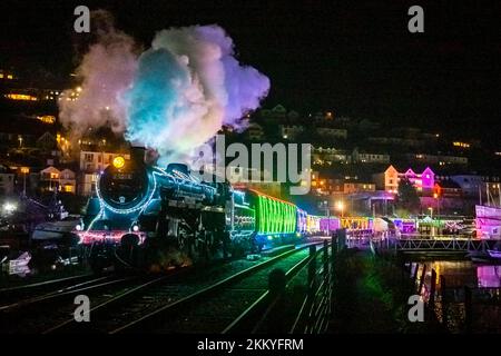 Kingswear, Devon, Regno Unito. 25th novembre 2022. Il treno di luci di Natale sulla ferrovia a vapore di Dartmouth che corre tra il 25th novembre e il 30th dicembre 2022, tira fuori dalla stazione Kingswear a Devon sulla strada per Paignton. Le carrozze e le locomotive a vapore del servizio festivo sono illuminate all'interno e all'esterno con luci colorate. Picture Credit: Graham Hunt/Alamy Live News Foto Stock