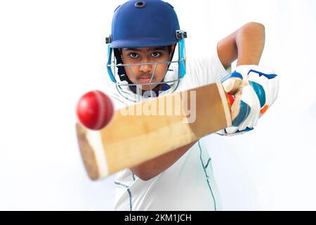 Ritratto di ragazzo che colpisce un colpo durante un gioco di cricket Foto Stock