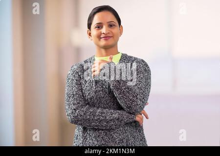 giovane donna indiana adulta in piedi davanti alla macchina fotografica Foto Stock