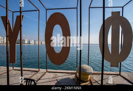 Lettere dalla parola 'ΚΙΝΗΜΑΤΟΓΡΑΦΟΥ' (CINEMA) come visto da dietro guardando la torre bianca di Salonicco Foto Stock