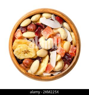 Miscela di frutta secca esotica con noci, miscela di percorso in una ciotola. Mirtilli rossi secchi, patatine di banana e cocco, papaia candita, mandorle, nocciole e anacardi. Foto Stock