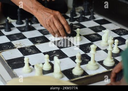 Scacchiera e mani, giochi di scacchi che sono familiari alla società in generale Foto Stock