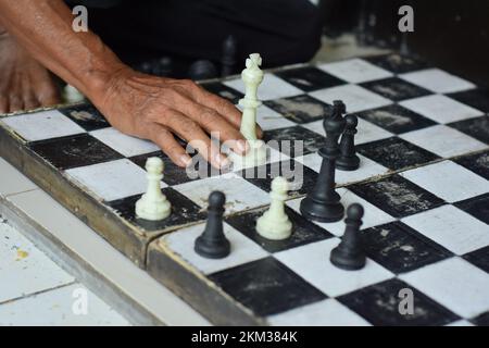 Scacchiera e mani, giochi di scacchi che sono familiari alla società in generale Foto Stock