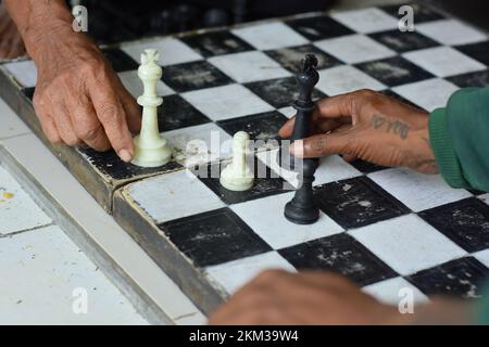 Scacchiera e mani, giochi di scacchi che sono familiari alla società in generale Foto Stock