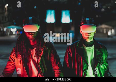 due uomini diversi utilizzano cuffie per esplorare il mondo informatico, nuove tecnologie per navigare sul web e meta verse Foto Stock