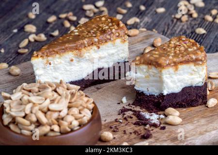 torta al cioccolato cremosa con caramello e arachidi tostate, torta con crema di formaggio e torta di spagna al cioccolato e caramello con noci Foto Stock