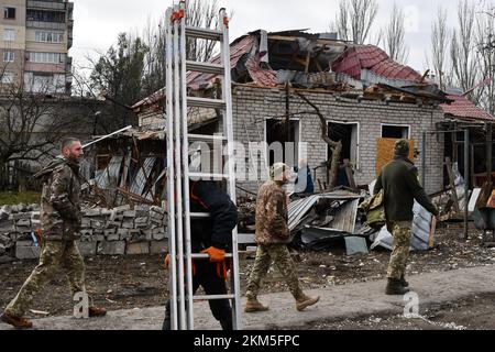 Kramatorsk, Ucraina. 25th Nov 2022. La gente passa davanti a una casa privata danneggiata dal bombardamento russo a Kramatorsk. Le infrastrutture energetiche dell'Ucraina sono nuovamente sotto attacco dalla Russia questa settimana, lasciando milioni di persone senza potere. Poiché le temperature scendono al di sotto del livello di congelamento in tutto il paese, vi è il timore che Mosca - lottando per vincere la guerra iniziata - sia "un'arma da guerra". E da nessuna parte è più chiaro come potrebbe essere che nelle città lungo la prima linea a est. Credit: SOPA Images Limited/Alamy Live News Foto Stock