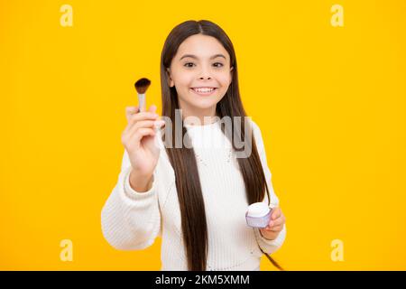 Bambina 12, 13, 14 anni che fa bellezza compongono con polvere e pennello. Bello adolescente che applica il trucco. Foto Stock