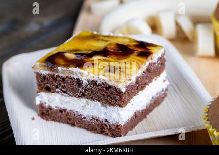 un pezzo di banana cake e banane fresche a fette, dessert di dolce pan di spagna, crema di burro con banane e ripieno di banana Foto Stock