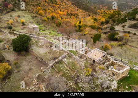 Veduta aerea di edifici in pietra a Maltiola, vicino al col de San Colombano in Corsica, circondato da alberi autunnali Foto Stock