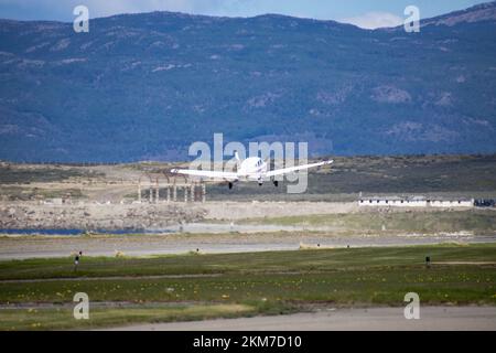 Un piccolo aereo monototore che parte da Ushuaia, Argentina. Con montagne sullo sfondo. Foto Stock