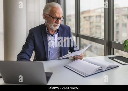 Elegante uomo d'affari adulto in un vestito, cercando di assumere qualcuno per la sua azienda. Foto Stock
