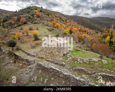 Veduta aerea di un edificio in pietra a Maltiola, vicino al col de San Colombano in Corsica, circondato da alberi autunnali Foto Stock