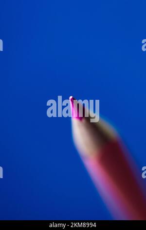 Matita rosa pastello isolata su sfondo blu Foto Stock