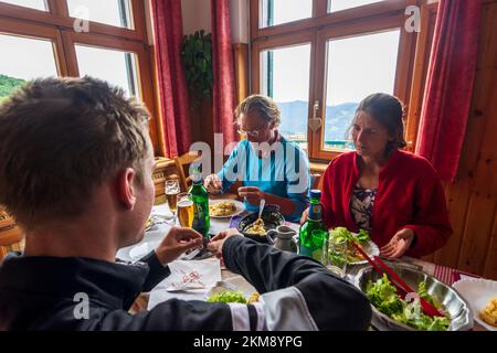 Vosges (Vogesen) Montagne: Escursionista di famiglia a pranzo al ristorante in rifugio Ferme Auberge du Hahnenbrunnen in Alsazia (Elsass), Alto Reno (Oberelsa Foto Stock