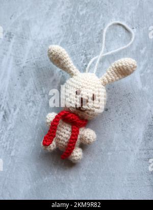 Bianco uncinetto coniglietto primo piano foto. Regalo di Natale fatto a mano. Modello animale Amigurumi. Foto Stock