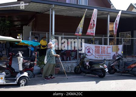 Pingtung, Taiwan. 26th Nov 2022. Una comunità indigena locale si vede camminare per una serie di striscioni per le campagne politiche per le elezioni locali a Mazia Township a Taiwan. La municipalità di Maja ha le elezioni locali più competitive tra tutte le municipalità indigene di Taiwan. Il comune di quasi sette migliaia di residenti indigeni delle tribù Payuan e Drekay ha 5 candidati che corrono per i capi del comune e 10 candidati che corrono per i rappresentanti del comune per le elezioni locali taiwanesi del 2022. (Credit Image: © Hesther ng/SOPA Images via ZUMA Press Wire) Foto Stock