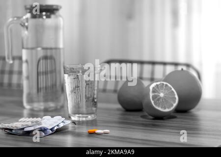 Primo piano di tangerini, arance e limoni freschi e biologici, capsule e tavolo rustico in legno su fondo bianco e nero . Vista laterale.fuoco selettivo Foto Stock