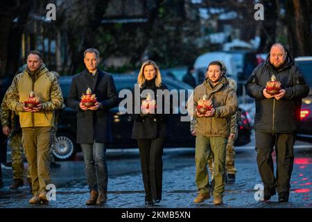 Un uomo non identificato, il primo ministro Alexander De Croo, la moglie di Zelensky Olena Zelenska, il presidente ucraino Volodymyr Zelensky e un uomo non identificato tengono con una torcia pezzi floreali, durante una cerimonia per commemorare l'Holodomor, durante una visita a Kyiv, Ucraina, sabato 26 novembre 2022. L'Holodomor, noto anche come la carestia del terrore o la Grande carestia, fu una carestia artificiale nell'Ucraina sovietica dal 1932 al 1933 che uccise milioni di ucraini. Il primo ministro De Croo e il ministro degli Esteri Lahbib sono arrivati sabato nella capitale Ucraina Kiev per una visita senza preavviso. Nove mesi Foto Stock