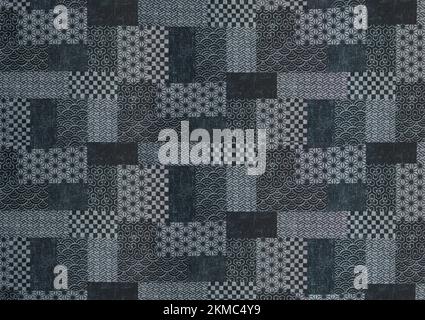 Grande sfondo texture di un disegno giapponese patchwork stampato su tessuto con forme geometriche tradizionali che raffigurano vari motivi come onde, h Foto Stock