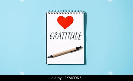 Come praticare la gratitudine. Parola gratitudine in un taccuino aperto sul tavolo. Nota apprezzare le cose buone, esprimere gratitudine a te stesso. Parola gratitudine e. Foto Stock