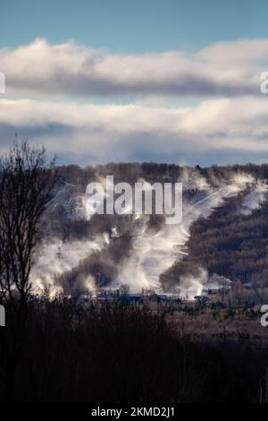 Cannoni da neve che innevano sulla Granite Peak Ski Hill a Rib Mountain, Wausau, Wisconsin poco prima che aprano, in verticale Foto Stock