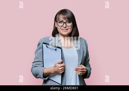 Donna d'affari con appunti su sfondo rosa Foto Stock