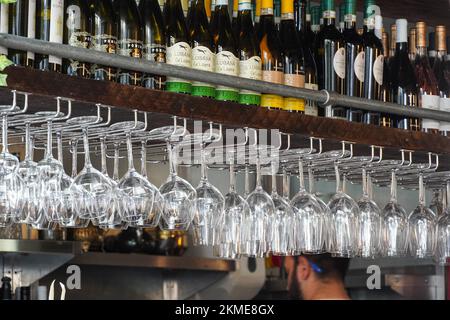 Bottiglie di vino sulla mensola di legno e bicchieri da vino su una cremagliera in ristorante, Londra Inghilterra Regno Unito Foto Stock