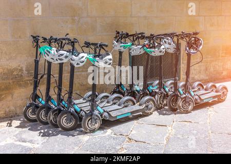 Scooter elettrici in affitto nel parcheggio Foto Stock