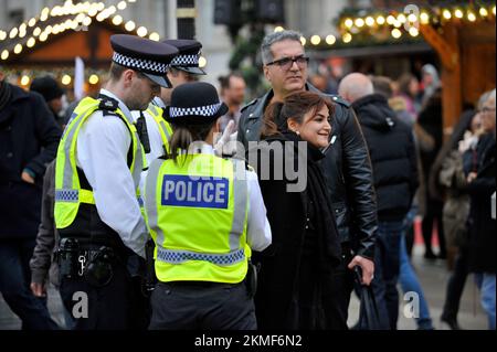 Londra, Regno Unito. 26th Nov 2022. Una donna in cappotto nero con il suo compagno in giacca di pelle presumibilmente sostenendo la monarchia iraniana insultare i manifestanti. La donna nella giacca nera ha punito la donna bionda in faccia ed è arrestata dalla polizia. Gli iraniani protestano in Trafalgar Square. Protesta a Londra per la morte di Mahsa Amini nelle mani della polizia morale iraniana per aver indossato in modo errato il suo hijab. Credit: JOHNNY ARMSTEAD/Alamy Live News Foto Stock